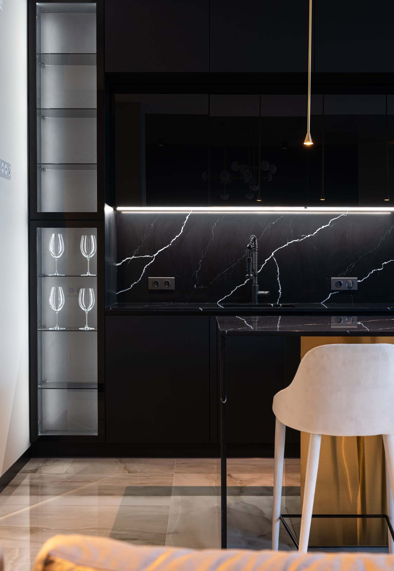 High-gloss black kitchen with lit backsplash and glass display shelving